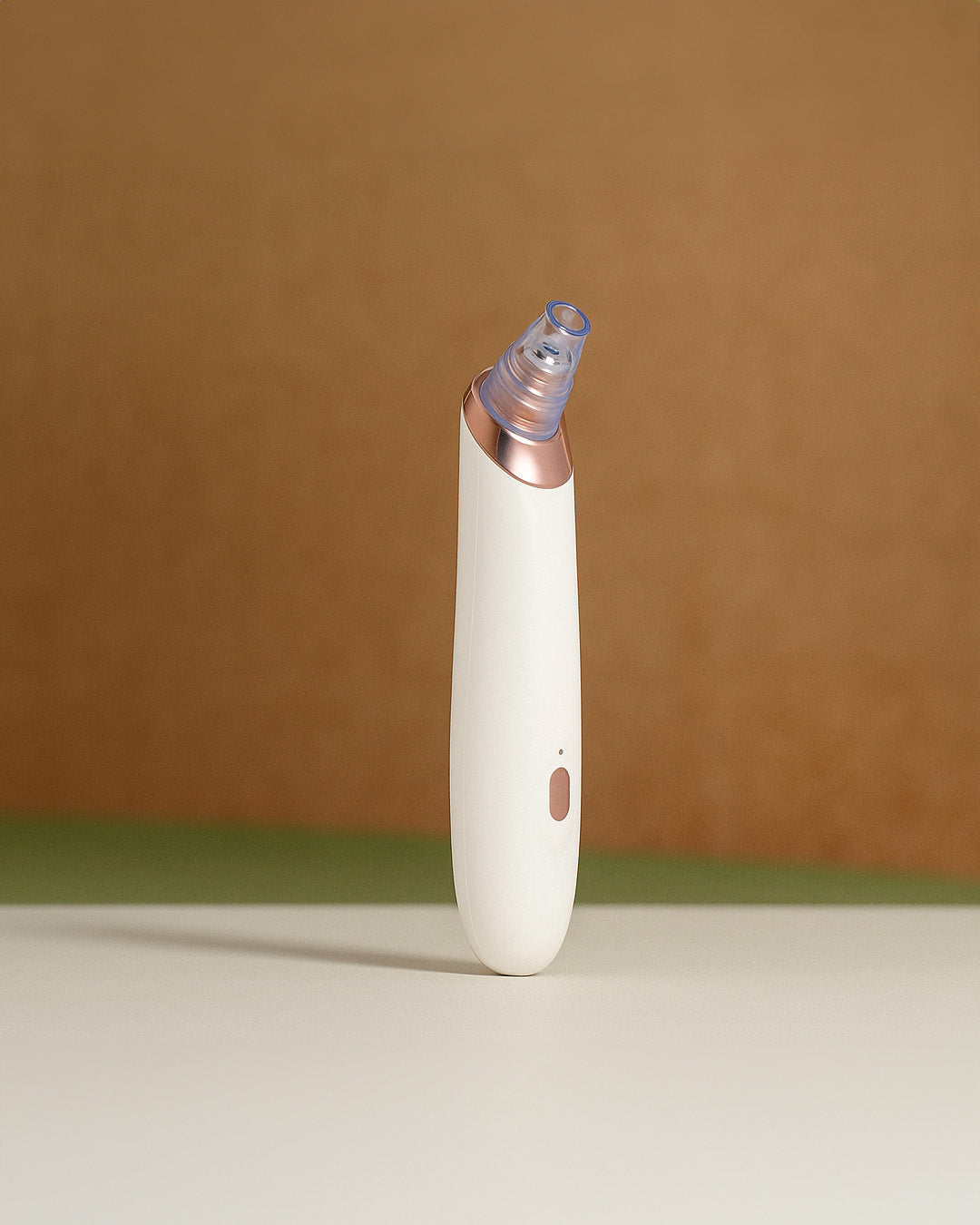 White and rose gold electronic acne device on a brown background