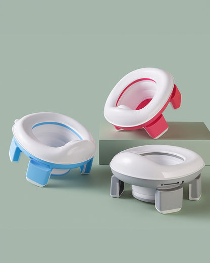 Three children's potty seats in different colors on a light green background