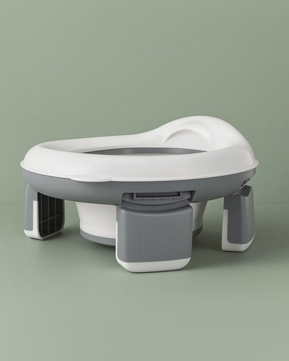 White and grey potty seat on a green background