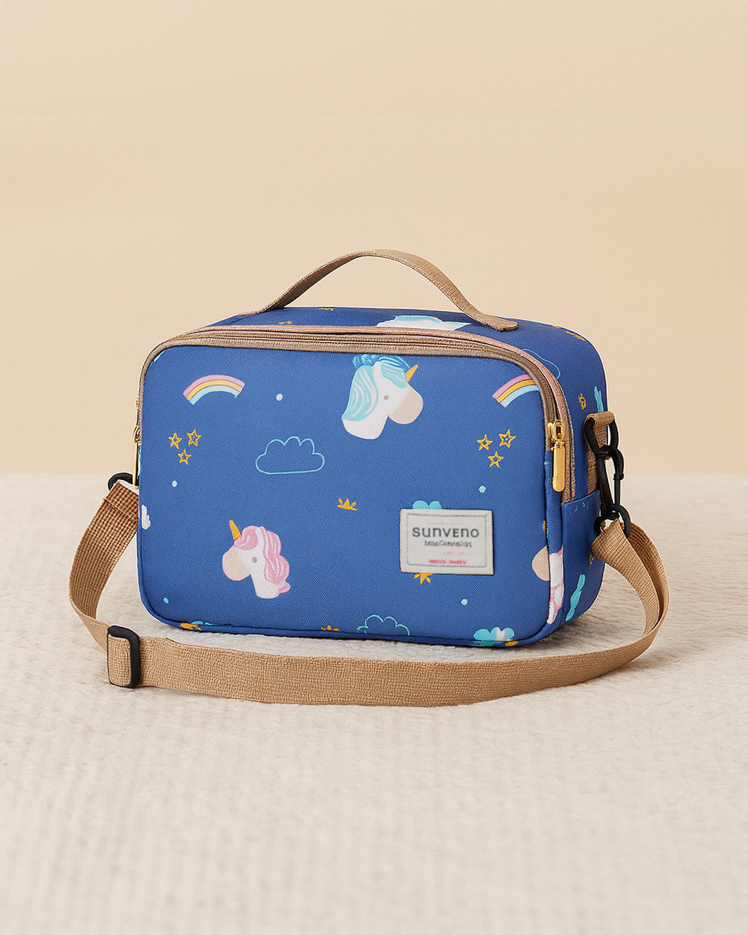 Blue baby diaper bag with unicorn and rainbow pattern on a beige background