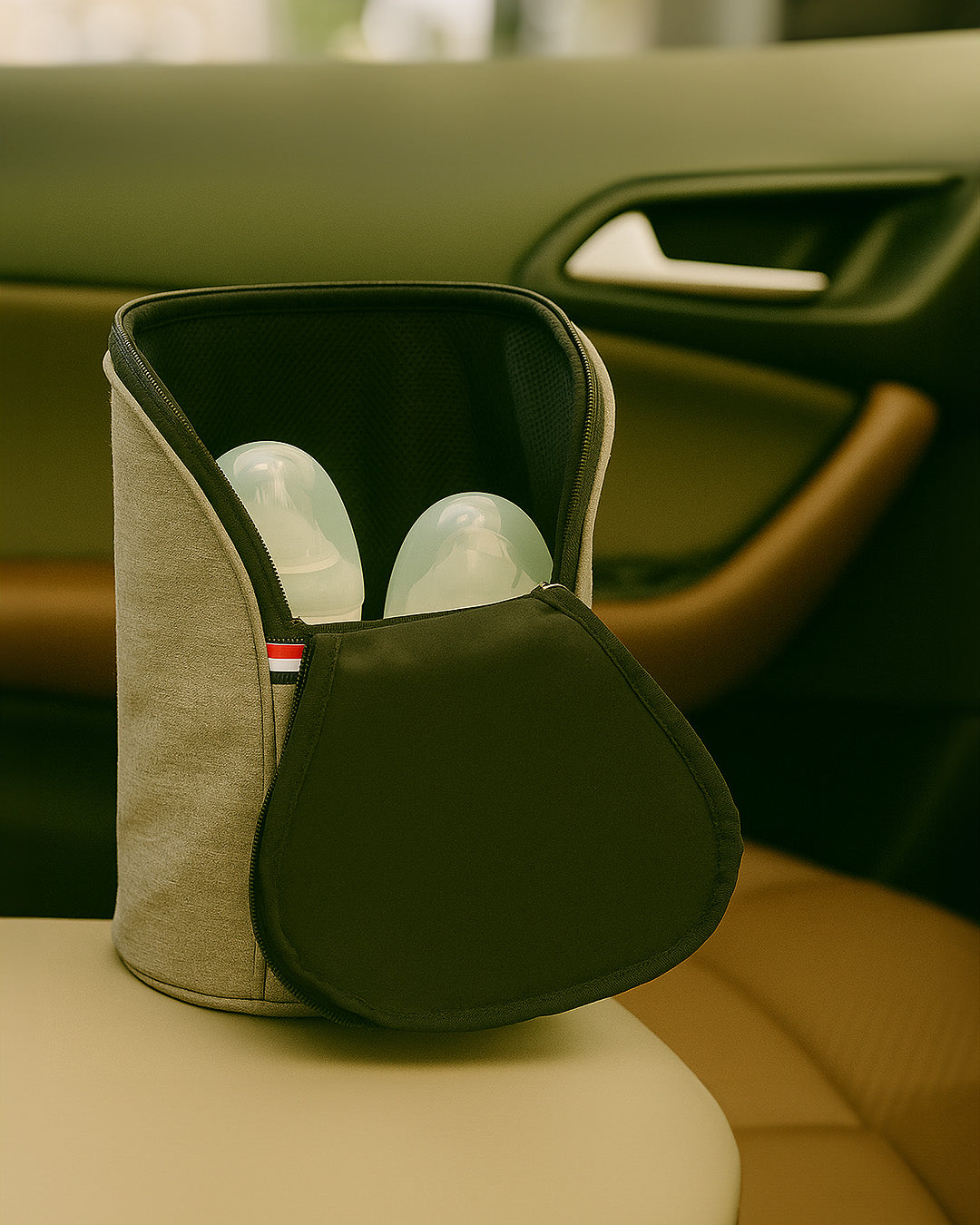 Car bottle warmer with bottles inside on a car seat.