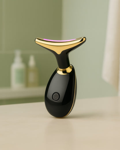Black and gold thermal facial massager on a neutral background