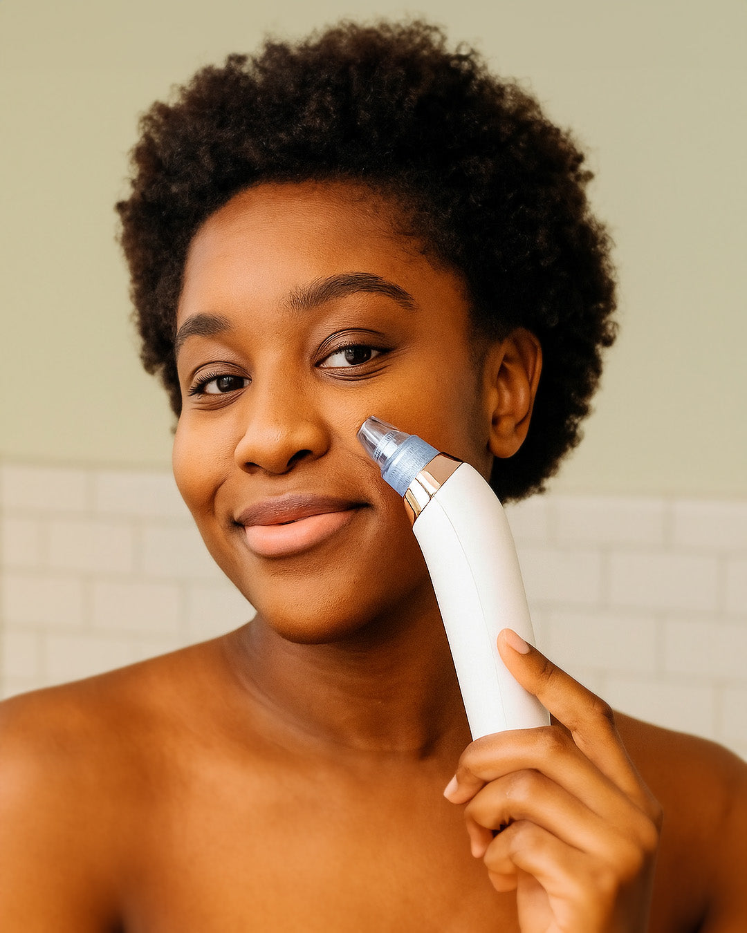 Person using a white electronic acne device on their face against a neutral background