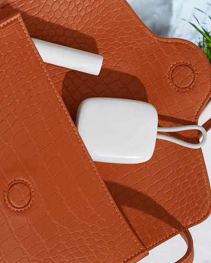 White Portable Toothbrush UV Steriliser with a cable inside a brown textured bag.