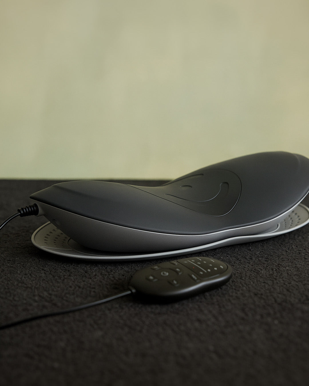 Black ergonomic stretcher and wrist rest on a dark surface with a neutral background