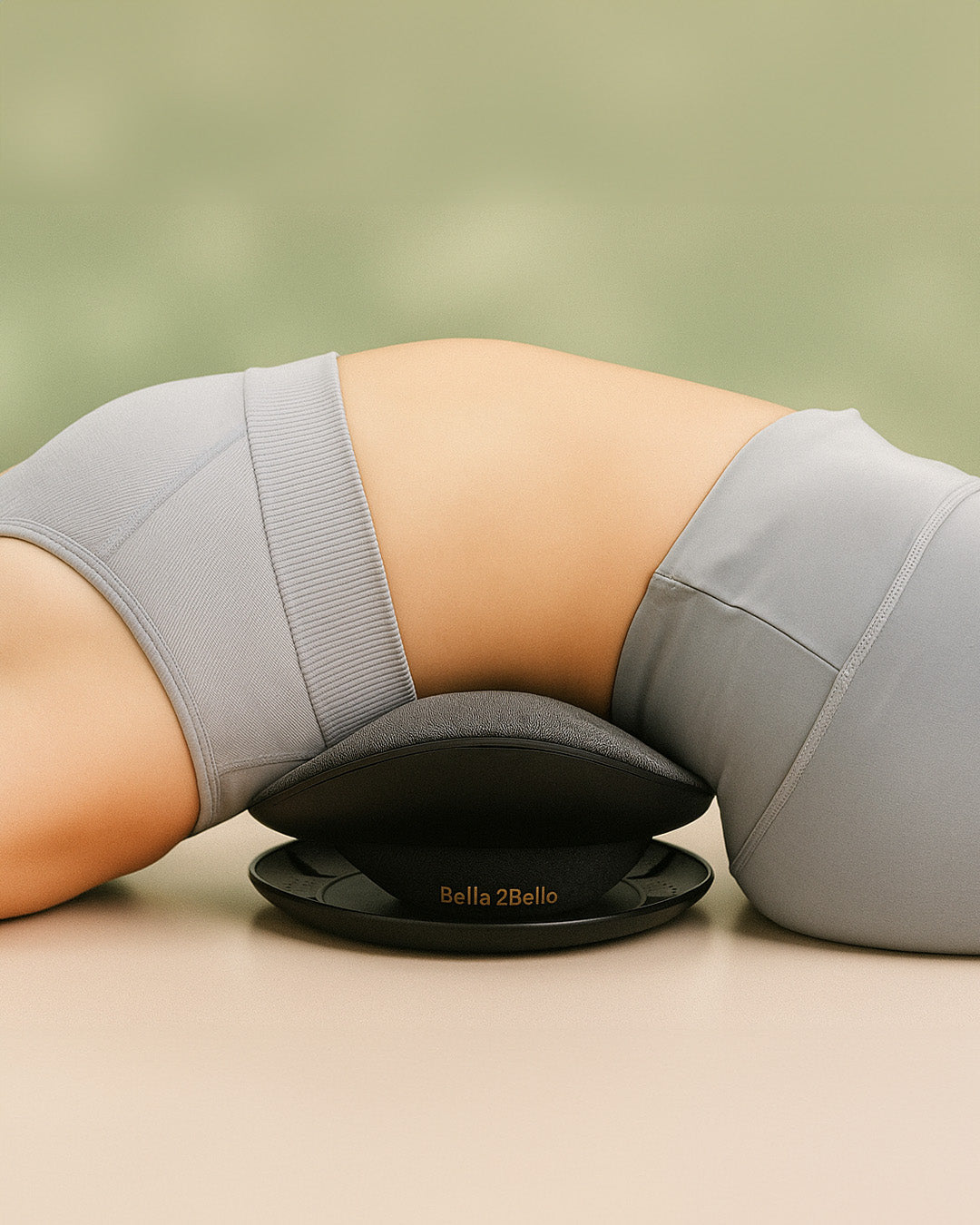 Person using a Bella Bello product on a beige surface with a green background